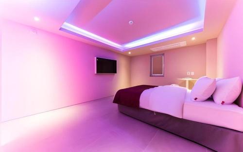 a purple bedroom with a bed and a tv at Bobo Hotel Hongdae in Seoul