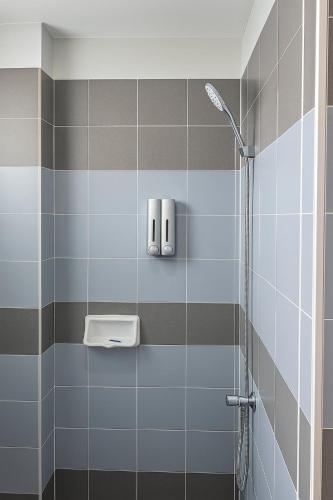 a bathroom with a shower with blue and gray tiles at Bangkok Place Apartment - EKAMAI BTS in Bangkok