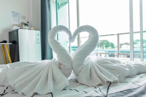 two white swans making a heart on a bed at The Sunset Bangsaen Hotel in Ban Rong Khoei