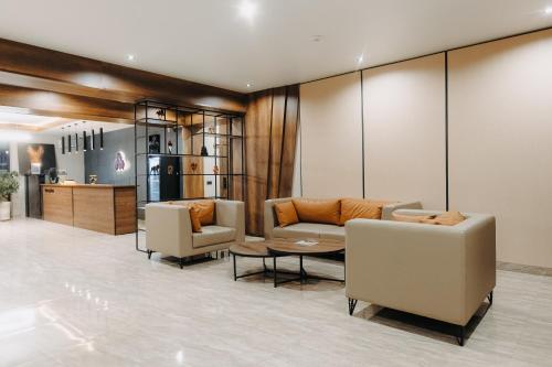 a lobby with couches and chairs and a table at Irislux in Taraz