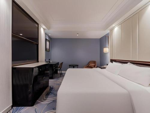 a hotel room with a large bed and a television at Jinjiang Metropolo Hotel Nanjing Confucius Temple Branch in Nanjing