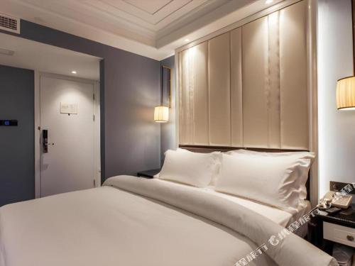 a bedroom with a large bed with white pillows at Jinjiang Metropolo Hotel Nanjing Confucius Temple Branch in Nanjing