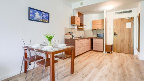 a kitchen and dining room with a table and chairs at Olympic Park I, Sun & Snow in Kołobrzeg