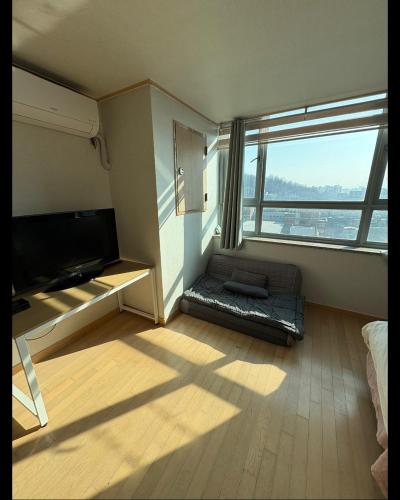 a living room with a large window and a couch at Hongdae Sinchon Skyview in Seoul