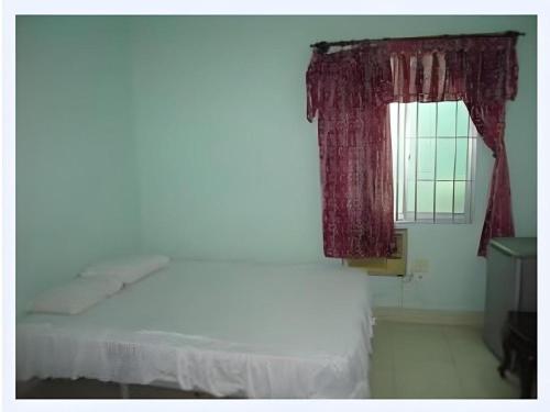 a bedroom with a white bed and a window at Nam Phuong Hostel 2 in Vung Tau