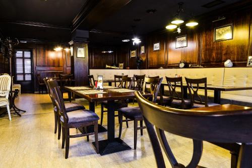 a restaurant with wooden walls and tables and chairs at Park House in Dej