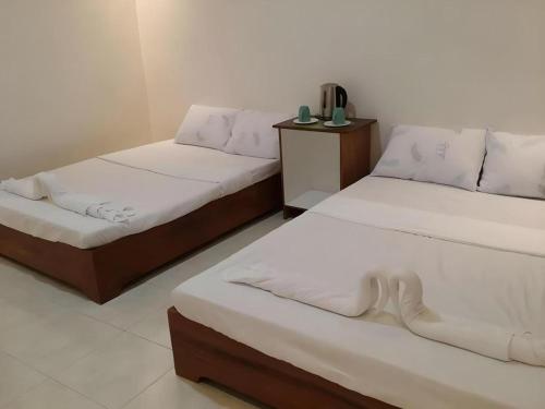 two beds sitting in a room with at Joaquim's Lodge in Luka