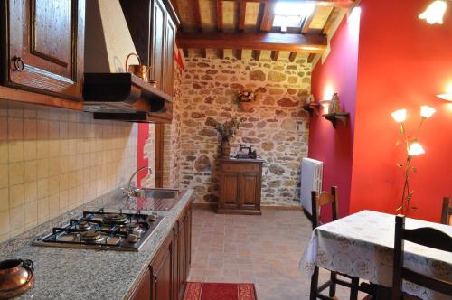 a kitchen with red walls and a stove top oven at Agriturismo Arcobaleno della Torretta in Giano dellʼUmbria