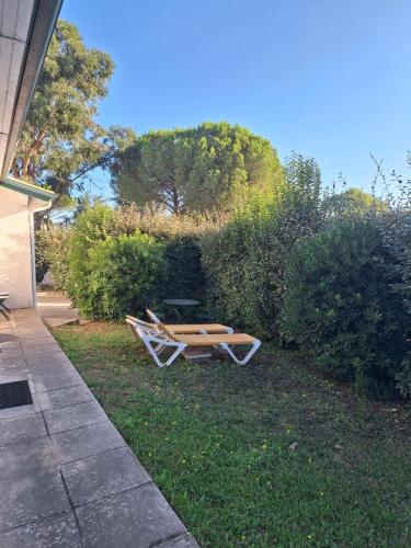 une table de pique-nique assise dans l'herbe à côté d'un bâtiment dans l'établissement Studio G Baillargues Montpellier Golf de Massane, à Baillargues