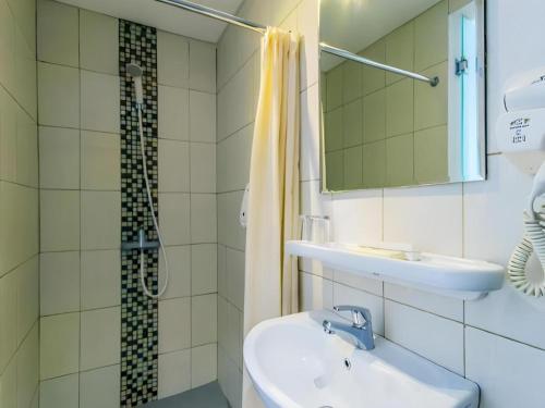 łazienka z umywalką i prysznicem w obiekcie Losari Sunset Hotel w mieście Kuta