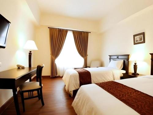 Ένα ή περισσότερα κρεβάτια σε δωμάτιο στο Colonial Hotel Makassar