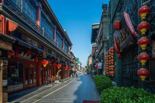a street in an asian city with red and yellow lights at Orange Hotel Beijing Tiananmen Dashilan in Beijing