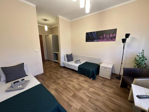 a small room with two beds and a couch at Pokoje Gościnne Rozbark in Bytom