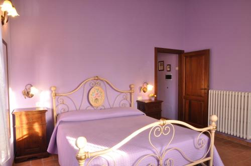 a bedroom with a white bed with purple sheets at Agriturismo Arcobaleno della Torretta in Giano dellʼUmbria