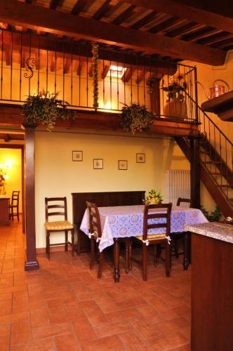 a dining room with a table and chairs and a staircase at Agriturismo Arcobaleno della Torretta in Giano dellʼUmbria