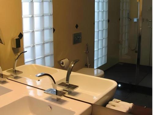 a bathroom with a sink and a toilet and a mirror at D Villas in Colombo