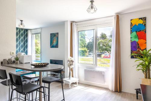 une salle à manger avec une table et des chaises et une fenêtre dans l'établissement chazi and cosy, à Toulouse