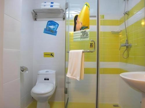 a bathroom with a shower and a toilet and a sink at 7 Days Inn Tianjin Development Zone 3rd Street Wanli in Binhai