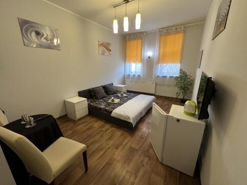 a living room with a bed and a couch and a chair at Pokoje Gościnne Rozbark in Bytom