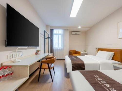 ein Hotelzimmer mit zwei Betten und einem Flachbildfernseher in der Unterkunft Jinjiang Inn Tianjin South Station in Tianjin