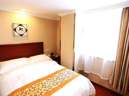 a bedroom with a bed and a large window at GreenTree Inn Nanjing Forestry University National Exhibition Center Express Hotel in Nanjing
