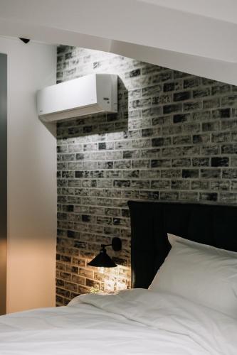 a bedroom with a brick accent wall and a bed at Karma Chic&Style Intera Villa in Korçë