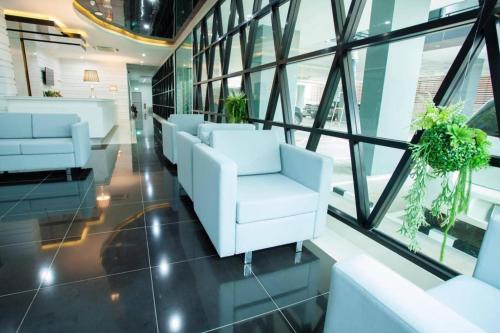 a waiting room with white chairs and windows at Thanburi Hotel in Udon Thani