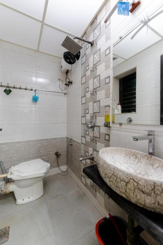 a bathroom with a sink and a toilet at Pearl Palace 4-Bedrooms Villa by Spacez with Private Theatre & Terrace in Mumbai