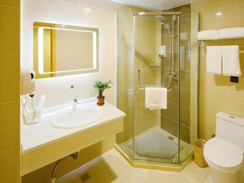 a bathroom with a sink and a shower and a toilet at GreenTree Inn Shanghai Railway Station Macao Road in Shanghai