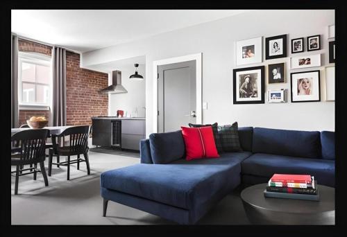a living room with a blue couch and a table at The George Montclair in Montclair