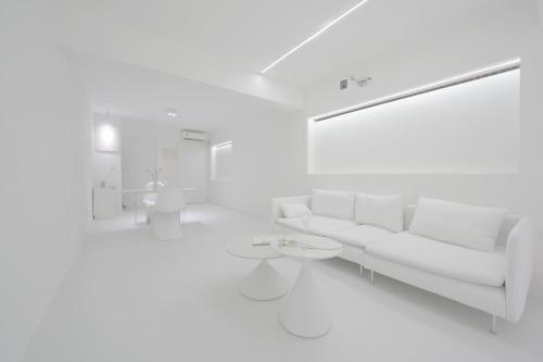 a white living room with a couch and a table at Daydreaming House under the Road in Chongqing