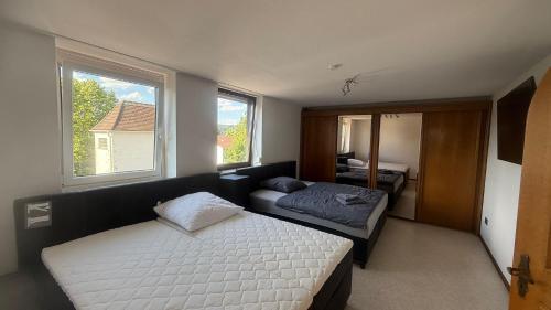 a bedroom with a bed and a couch and two windows at Wohnung Münchnerstrasse 54 Simbach am Inn Mü54 1 gross in Simbach am Inn