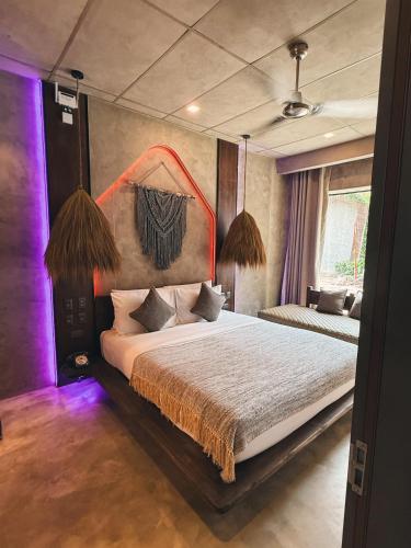 a bedroom with a large bed with purple lighting at Diwatu Villas in El Nido