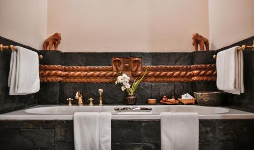 bagno con lavandino, asciugamani e specchio di The Dwarika's Hotel a Kathmandu