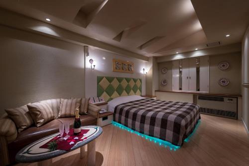a hotel room with a bed and a couch at ホテル フェスタ 横須賀 in Yokosuka