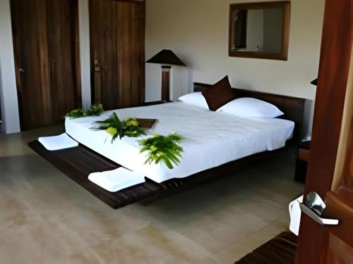 a bedroom with a large bed with plants on it at Le Manumea Hotel in Apia