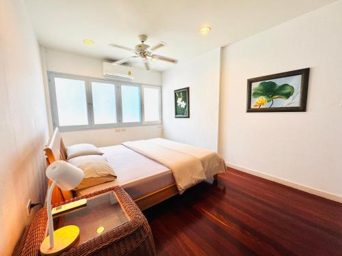 a bedroom with a bed and a ceiling fan at Tiki White House in Ban Nong Chaeng