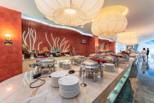 Nha Trang Prince Hotel في نها ترانغ: مطعم يقدم بوفيه مفتوح مع أطباق وثريات