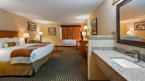 a hotel room with a bed and a sink at Best Western Rama Inn in Ephrata