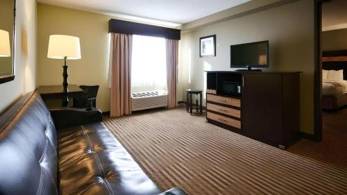 a hotel room with a couch and a television at Best Western Rama Inn in Ephrata
