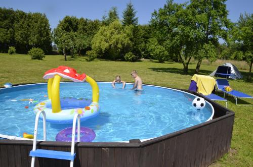 two people in a swimming pool with a soccer ball at Vila Kateřina in Broumov