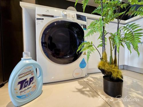 a bottle of laundry detergent next to a washing machine at Spacious Cozy Elysia Suite Johor Bahru Legoland in Iskandar Puteri
