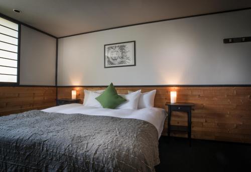 a bedroom with a large bed and two night stands at The Phat House in Hakuba