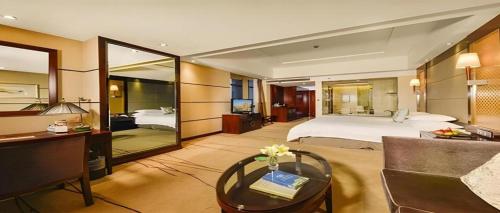 a hotel room with a bed and a desk and a bedroom at Gaosu New Century Hotel International Anhui in Hefei
