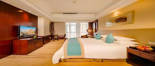 a hotel room with a large bed and a television at Gaosu New Century Hotel International Anhui in Hefei
