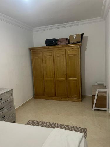 a room with a wooden cabinet with a suitcase on top at Chic furnished apartment, Center in Tangier