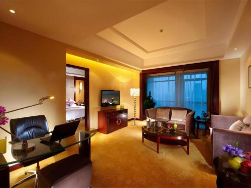 a living room with a couch and a table at Gaosu New Century Hotel International Anhui in Hefei