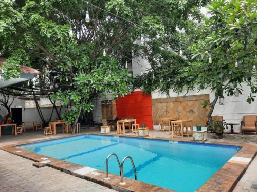 a pool with tables and chairs in front of a building at Pomelotel Patra Kuningan Jakarta in Jakarta
