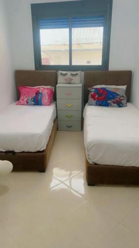 a bedroom with two twin beds and a window at Chic furnished apartment, Center in Tangier