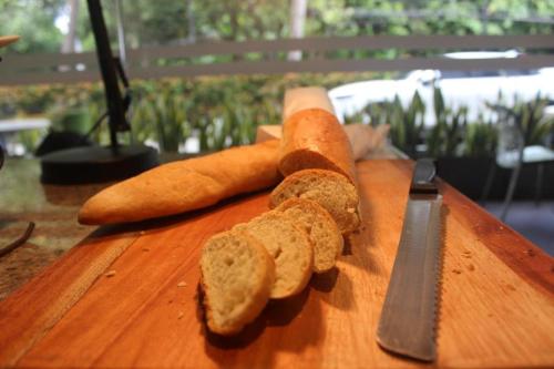 a cutting board with two carrots and a knife at Pomelotel Patra Kuningan Jakarta in Jakarta